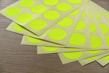 A set of yellow circle paper sticker label on wooden background.