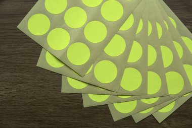 A set of yellow circle paper sticker label on wooden background.