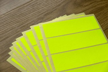 A set of yellow rectangular paper sticker label on wooden background.