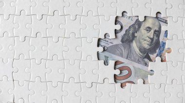 Yapbozun boş bir alanının üst görünümü dolar banknotlarıyla dolu.