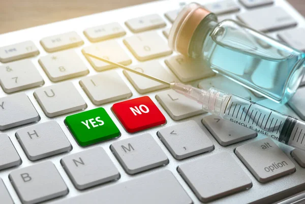 A bottle of vaccine, syringe and keyboard with green and red button represent YES and NO.