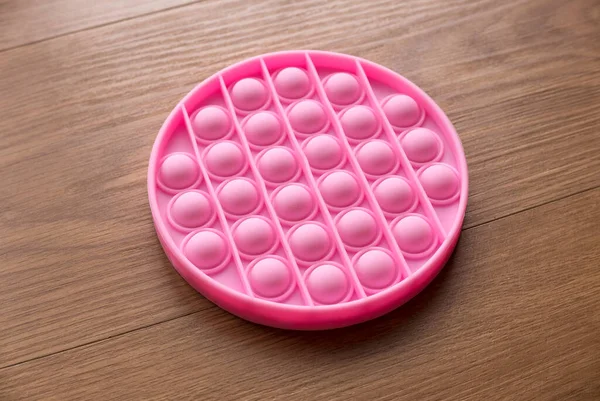 Pink Stress Sensory Toy Fidget Push Pop Isolated Wooden Background — Stockfoto