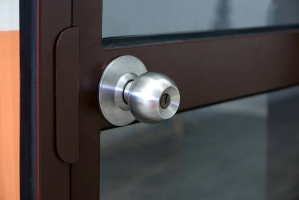 Brown steel door frame with a stainless steel door knob.