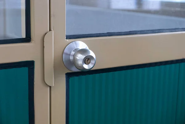 Cream steel door frame with a stainless steel door knob.