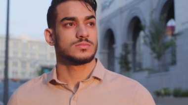 Aşırı yakın plan erkek ciddi üzgün yüz çekici başarılı dalgın sakallı iş adamı Hispanik patron şehirde dikilip uzaklarda hayal kuruyor.