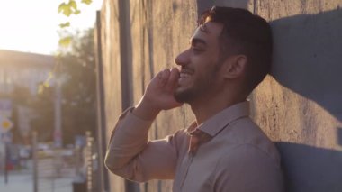 Yakışıklı, sakallı, ispanyol, Arap, iş adamı, taş duvarın yanında duran, cep telefonuyla konuşan, akıllı telefon konuşmalarıyla konuşan, şehirdeki kablosuz cep telefonu kullanan adam.