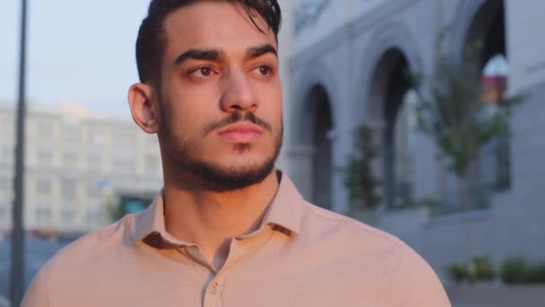 Екстремальний крупним планом чоловік серйозне сумне обличчя привабливе молодий успішний бородатий арабський бізнесмен хлопець його лідер, що стоїть у місті на вулиці, дивлячись на віддалені мрії — стокове відео