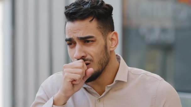 Porträtt av olycklig indisk sjuk kille hosta lider symptom på Covid-19. Hispanic affärsman hostar och håller näve nära munnen. Utbrott av coronavirus pandemisk epidemisk influensa astma — Stockvideo