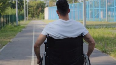 Tekerlekli sandalyede engelli bir genç yaz stadyumu koşu bandında elleri kullanarak engelli bir adam Engelli Olimpiyatları 'na hazırlanıyor. Spor sakatlığı olan milenyum sporcusu.