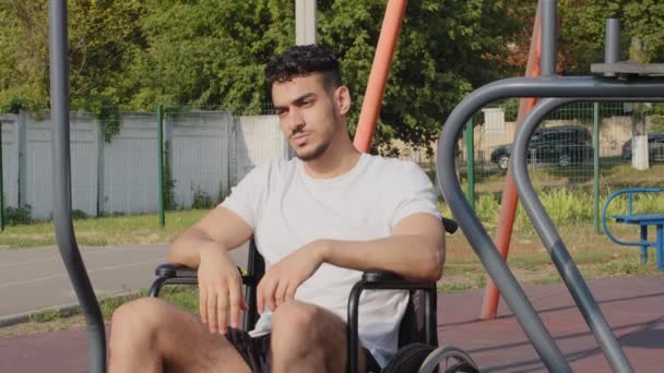 Smutný Blízký východ indický bývalý sportovec obdržel sportovní zranění, Mladý muž s postižením sedí na invalidním vozíku na stadionu obavy z neschopnosti trénovat, neúspěšná kariéra, potřebuje psychologickou pomoc — Stock video