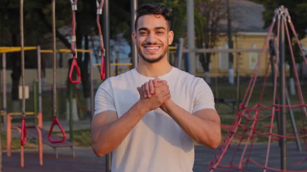 El joven atleta árabe muestra un gesto de apretón de manos, demuestra comunidad, apoyo, desea éxito y victoria a los atletas antes de la competición. Milenial oriente medio indio deportista en el estadio — Vídeos de Stock