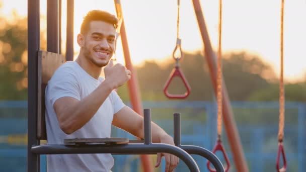 Confiado saludable milenario Oriente Medio chico atlético árabe le invita a ir en los deportes, recomienda un estilo de vida saludable. Joven atractivo hombre de deporte indio anuncia equipo gratuito para el entrenamiento — Vídeo de stock