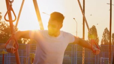 Şehir stadyumunda sabah antrenmanı sırasında simülatörde antrenman yapan Ortadoğu Hindistanlı atletik adam. Genç sporcu güçlü kaslı Arap adam etkili ekipman kullanarak pazı egzersizleri yapıyor.