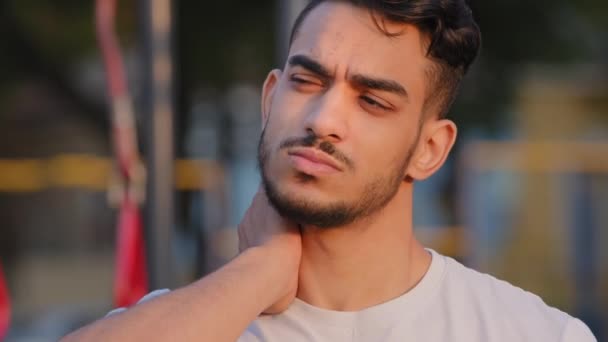 中東アラブ人男で白いtシャツで物理的な不快感不健康な疲れインドのミレニアルスポーツマン閉じ目のための首の痛みマッサージ緊張した筋肉を緩和関節肩の痛みの概念 — ストック動画