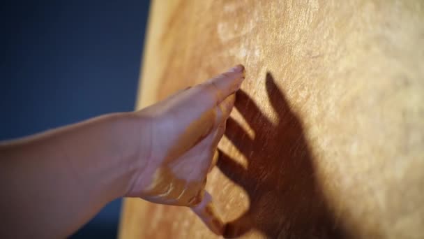 Silhouette of hands talented creative woman artist slowly moves hand in oil paint over gold painting, like a brush. Creation plot of picture for master class in art studio. Fingers touch canvas gently — Stock Video