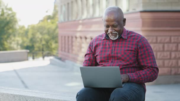 Szczęśliwy emerytowany afrykański amerykański mężczyzna w wieku klient banku lub sklepu pokazując kciuki w górę gest, zadowolony, zaleca usługi online. Starszy czarny człowiek działa i gra zdalnie, przyniósł dobre wysokie zyski — Wideo stockowe