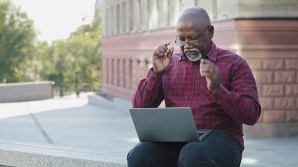 Černý starší muž sundává brýle masážní nos most cítí nezdravé snížit oční zátěž po dlouhém používání notebooku, s přestávkou od PC, počítačové vidění syndrom způsobený elektronickým zařízením nadužívání — Stock video
