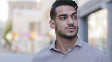Şehir caddesinde duran genç sakallı Arap adamın portresini kapat ve etrafa dikkatlice kağıt bardaktan çay içerek bak. İspanyol işadamı dinlenmeyi düşünüyor. Kahve içiyor ve binaya bakıyor.