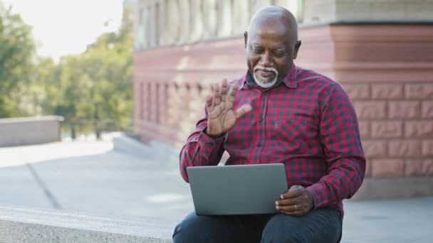 Ευτυχισμένος ηλικιωμένος μαύρος παππούς κάνει βιντεοκλήση, κοιτάζει την κάμερα laptop, Αφροαμερικάνος συνταξιούχος ώριμος άντρας επικοινωνεί με εγγόνια χρησιμοποιώντας σύγχρονο gadget, ηλικιωμένος μοιράζεται καλά νέα — Αρχείο Βίντεο