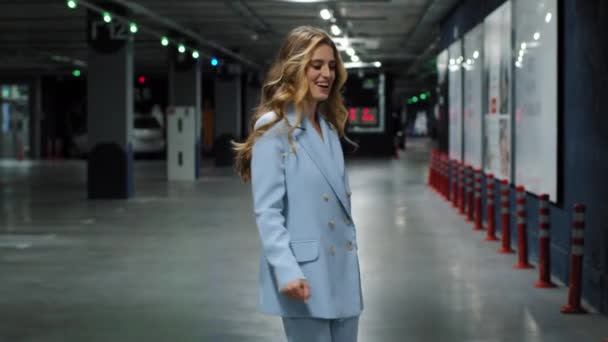 Hermosa hermosa rubia activa positiva con el pelo largo volando en el aire caucásico millennial mujer de negocios girando girando en el estacionamiento en interiores bailando teniendo divertido movimiento de baile girando sonriendo — Vídeos de Stock