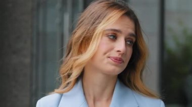 Açık hava portresi genç ve güzel stresli üzgün iş kadını kızgın bir hoşnutsuzlukla kameraya bakıyor. Kadın rahatsız yüz ifadesine yakın çekim. Stres sorunu kavramı.