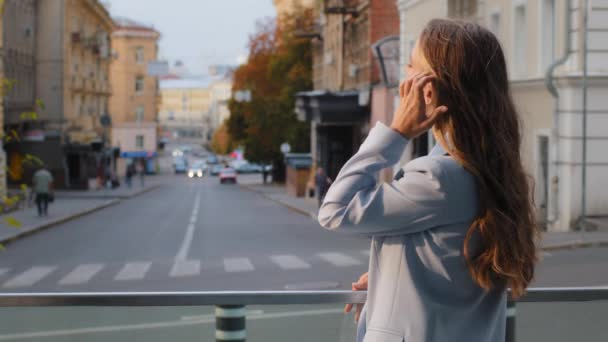 Vissza nézet kaukázusi gyönyörű fiatal szőke lány diák üzlet hölgy hosszú haj kék öltönyben áll az erkélyen terasz cég iroda élvezi a városi utcára néző pihenő pihenés szünetben — Stock videók