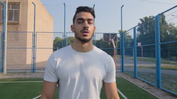 Fim do treino, bom trabalho. Cansado indiano médio oriental atlético homem limpando suor da testa deixa estádio depois de cansativo cardio. Jovem fisiculturista aspirante ou jogador de futebol descansando após o aquecimento — Vídeo de Stock