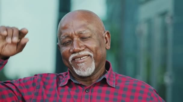 Portrait d'homme afro-américain âgé positif avec barbe grise regarder la caméra faire appel vidéo vague main bienvenue dialogue partenaire. Sourire adulte de l'âge de la retraite invite, annonce des services — Video