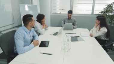 Çeşitli iş adamlarının tasarımcıları takım çalışması sırasında alkışlıyorlar, Hint grup lideri ve Arap ortakları şirket brifinginde başarılı takım çalışmasını kutluyorlar.