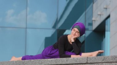 Müslüman İslami Arap Suriyeli Hintli kadın tesettürlü kız Yogi sporcu kadın jimnastikçi sicim üzerinde oturuyor iyi esneyen spor yoga eğitimi gerilimi şehrin arka plan esnekliği kavramını geliştiriyor