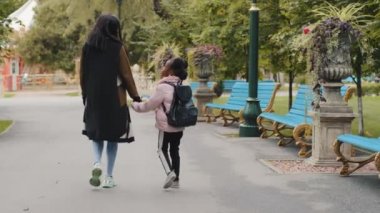 Arkaya bakan Afrikalı kadın anne, küçük Afro-Amerikalı kızı elleriyle tutuyor. Şehir parkına geri dönüyor, ilkokul dersine geri dönüyor. Sırt çantalı küçük siyah öğrenci, annenle birlikte eve gidiyor.