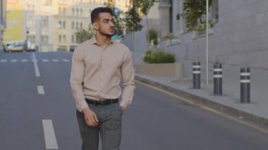 İspanyol genç adam Arap işadamı modern şehir binasının arka planında yürüyor. Kendine güveni tam, sakallı bir adam sokakta yürüyor. Yakışıklı turist tek başına dışarı çıkıyor, dinleniyor.