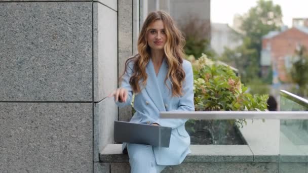 Hermoso éxito caucásico millennial mujer de negocios estudiante jefe gerente empleado femenino se sienta con el ordenador portátil en la terraza balcón en la oficina mirando la cámara muestra signo ok gesto bien éxito victoria — Vídeo de stock