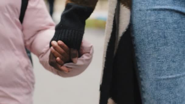 Close up irriconoscibile afro-americano nero madre donna e figlia bambino bambino bambino camminando fuori tenendo le mani insieme a strada passeggiata vacanza all'aria aperta. Concetto di relazione familiare — Video Stock