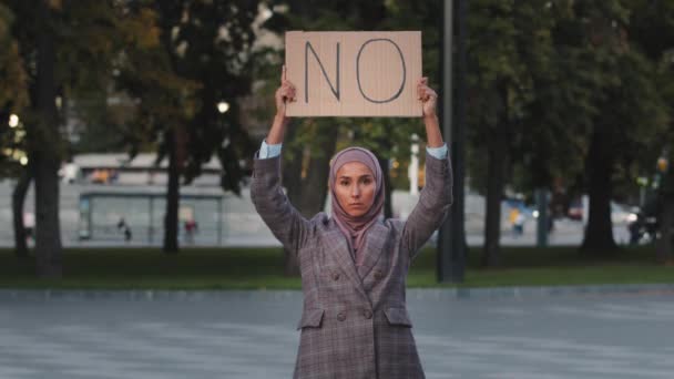 Detener el concepto de racismo La mujer musulmana inmigrante árabe en el hiyab protesta contra la discriminación vacunación vax de pie en la ciudad. Chica islámica sosteniendo pancarta de lema de cartón con texto sin desacuerdo negativa — Vídeo de stock