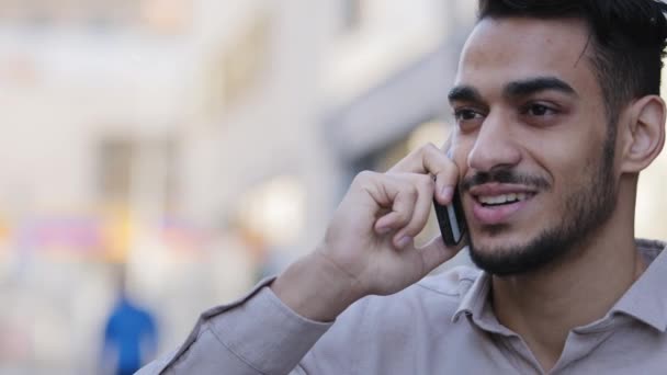 Hispano adulto joven hombre de negocios hablando de teléfono móvil en la calle bebiendo té de café caliente. Exitoso empresario árabe responder sí llamada positiva con el teléfono inteligente fuera de primer plano. Tipo hablando de teléfono celular — Vídeo de stock