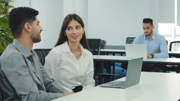 Indiska och kaukasiska affärspartners diskuterar nya projekt vid mötet i coworking med bärbar dator, interagera, dela tankar utveckla idéer som ger hög fem. Mentorskap och kompetensdelning — Stockvideo