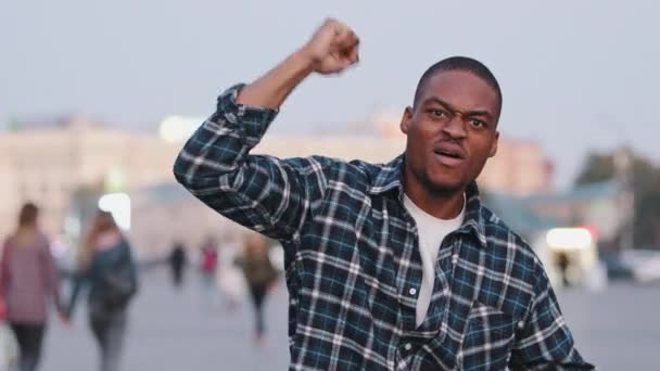 Fiducioso motivato forte potere afro-americano uomo razza mista ragazzo in piedi in città puntando il dito contro la fotocamera parlando mostrando con mano gesti pugno contro il razzismo discriminazione razziale solidarietà — Video Stock