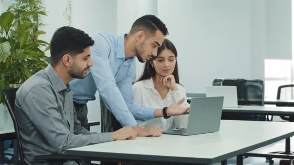 Drei Kollegen, die zusammen über Teamarbeit bei Computerprojekten sprechen, Geschäftsleute, die am Arbeitsplatz lachen, lächelnde Mitarbeiter, die Spaß am Gespräch im Büro haben — Stockvideo