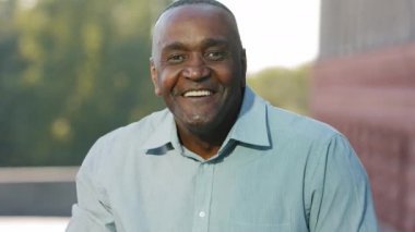 Kapalı kapılar ardında neşeli yetişkin Afro-Amerikan bir adam gülüyor, el sallıyor, her şeye burnunu sokan, izleyici. Zenci erkek çalışan yöneticisi veya uzaktan yayın yapan girişimci.