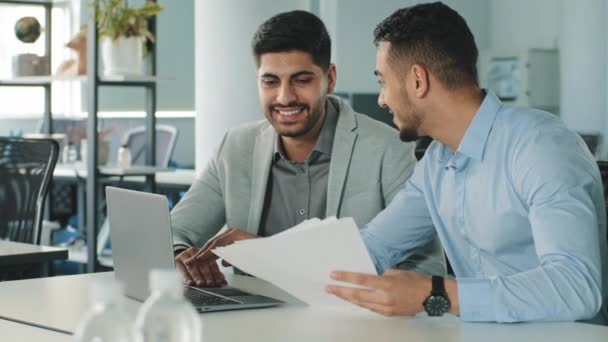 Alegre positivo amistosos hombres de negocios socios colegas que sostienen contrato de documento mirando la pantalla del ordenador portátil discutir ideas que se divierten durante el descanso en la oficina. Buenas relaciones comerciales, concepto — Vídeos de Stock