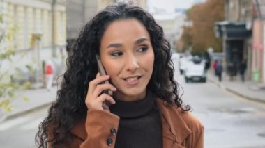 Şehirde cep telefonundan konuşan yakın plan bir kadın. Portre genç kız cevap vermek akıllı telefon modern cihaz aramak gülen sohbet eden hücresel bağlantı iyi iletişim wifi sokak