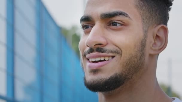 Gelukkige glimlachende jongeman die opzij kijkt, zich verheugt over de ontmoeting, wenkbrauw opheft, vreugde voelt, verrassing, vreugde. Close-up portret Happy millennial Midden-Oosten Indiase man met brede witte tanden glimlach — Stockvideo