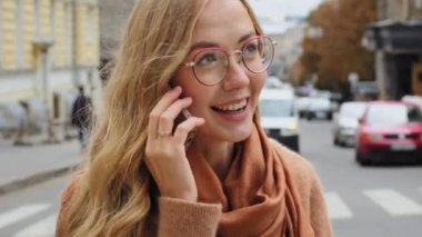 Yakın plan duygusal genç milenyum kızı telefonda konuşurken beyaz kadın telefonda konuşan güzel gülümseyen bir kadının mobil sohbet portresinin keyfini çıkarıyor.