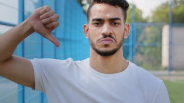 Üzgün sporcu, haksız skorun öfkesine kapılan futbol maçı, rekabet sonuçlarına katılmayan, hoşlanmayan, reddeden, küçümseme hareketi sergiliyor. Kızgın Orta Doğulu genç bir Hintli yazın spor giyim kuşamında.