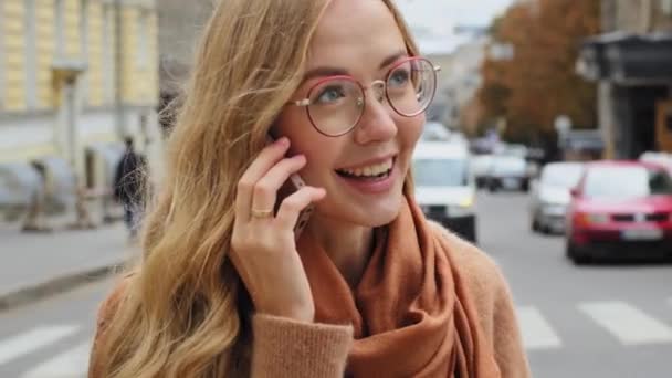 Yakın plan duygusal genç milenyum kızı telefonda konuşurken beyaz kadın telefonda konuşan güzel gülümseyen bir kadının mobil sohbet portresinin keyfini çıkarıyor. — Stok video