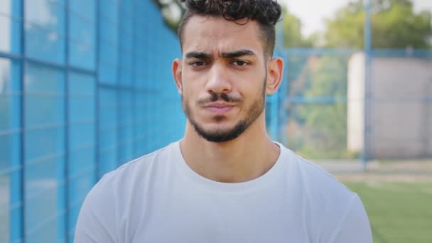 Portrett sinte misfornøyde unge studenter i Midtøsten i sommersportstøy. Oppskaket trist idrettsutøver holder hodet med hendene, er uenig i resultater fotballkamp, konkurranse, rasende over urettferdig score – stockvideo