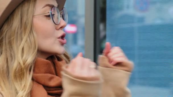 Überraschte junge schöne Frau im Freien emotionale Mädchen mit Hut und Brille glücklich springen erstaunt aufgeregte Dame Gefühl Freude kaukasischen weiblichen aktiv gestikulierenden Händen lockige blonde Walkin auf der Straße — Stockvideo