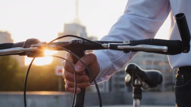 Detailní záběr mužské ruky držící řídítka na kole. Dospělý dospělý člověk cestuje po městě osobním ekologickým transportem. Péče o životní prostředí snižující škody způsobené koncepcí výfukových plynů — Stock video