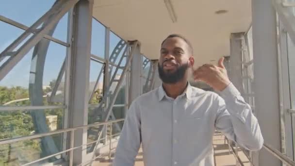 Retrato afro-americano empresário chefe líder étnico preto afro barbudo cara caminha no escritório corredor com janelas panorâmicas sofrendo de calor alta temperatura tempo limpa suor da testa — Vídeo de Stock